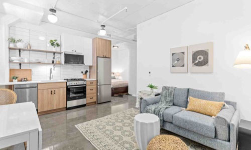 A bright, modern apartment living room in the North Loop of Minneapolis, featuring large windows, stylish furniture, and a vibrant urban view - Apartments for lease